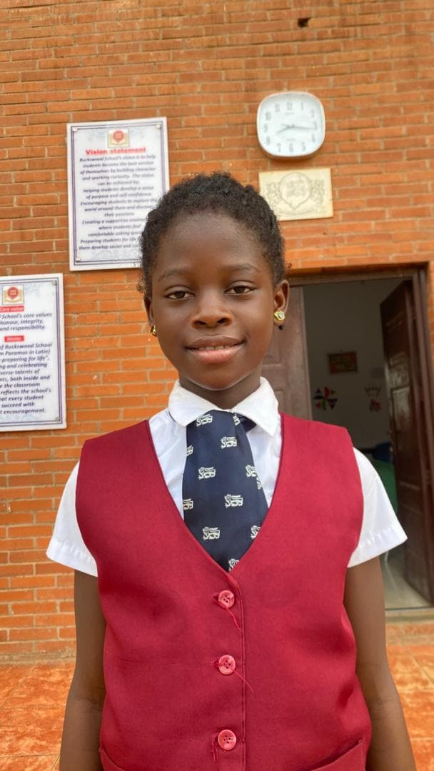 Aliyah Jimoh, OVC Beneficiary smiling in school uniform